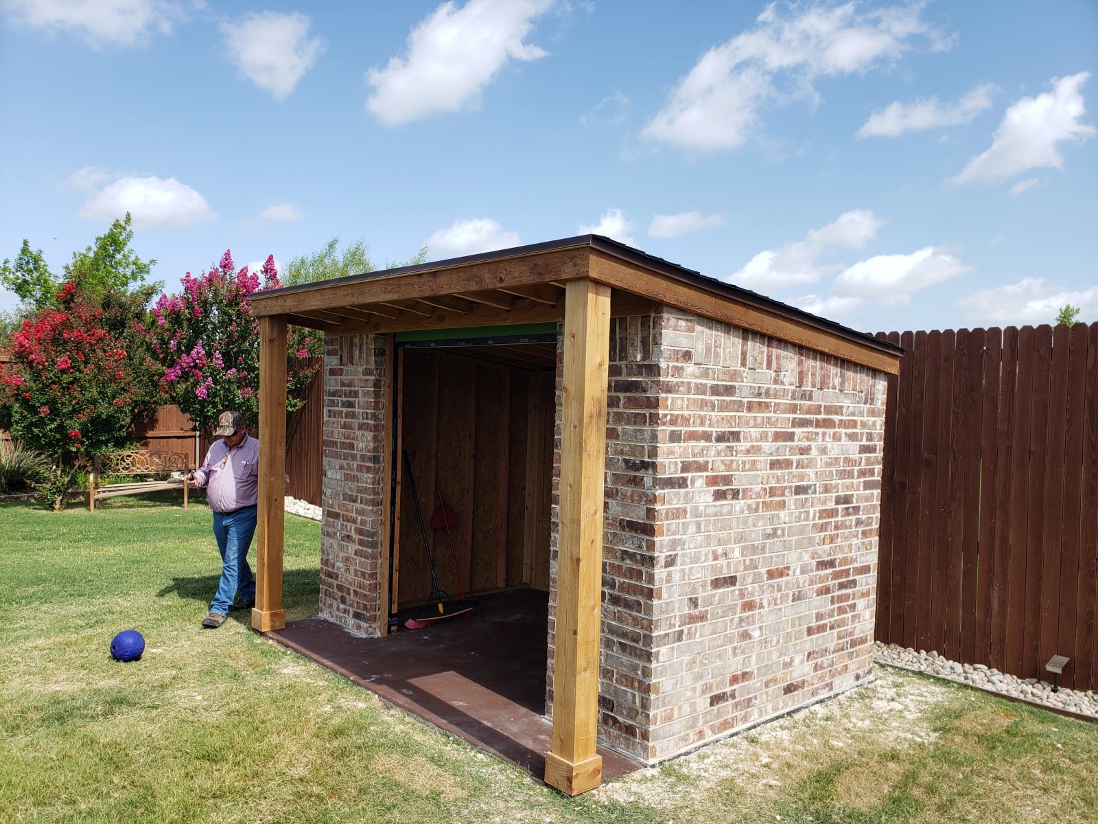 Brick masonry complete with cedar trim and standing-seam metal roof installed