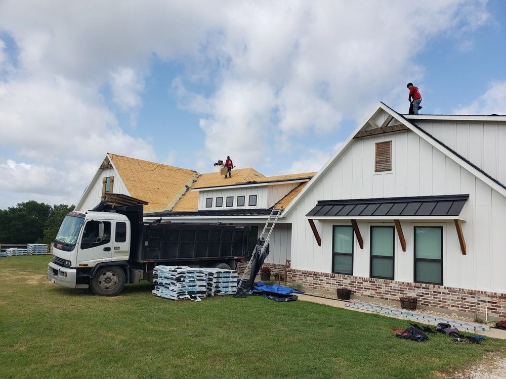 Roofing material delivery truck parked in front of a home during a re-roof