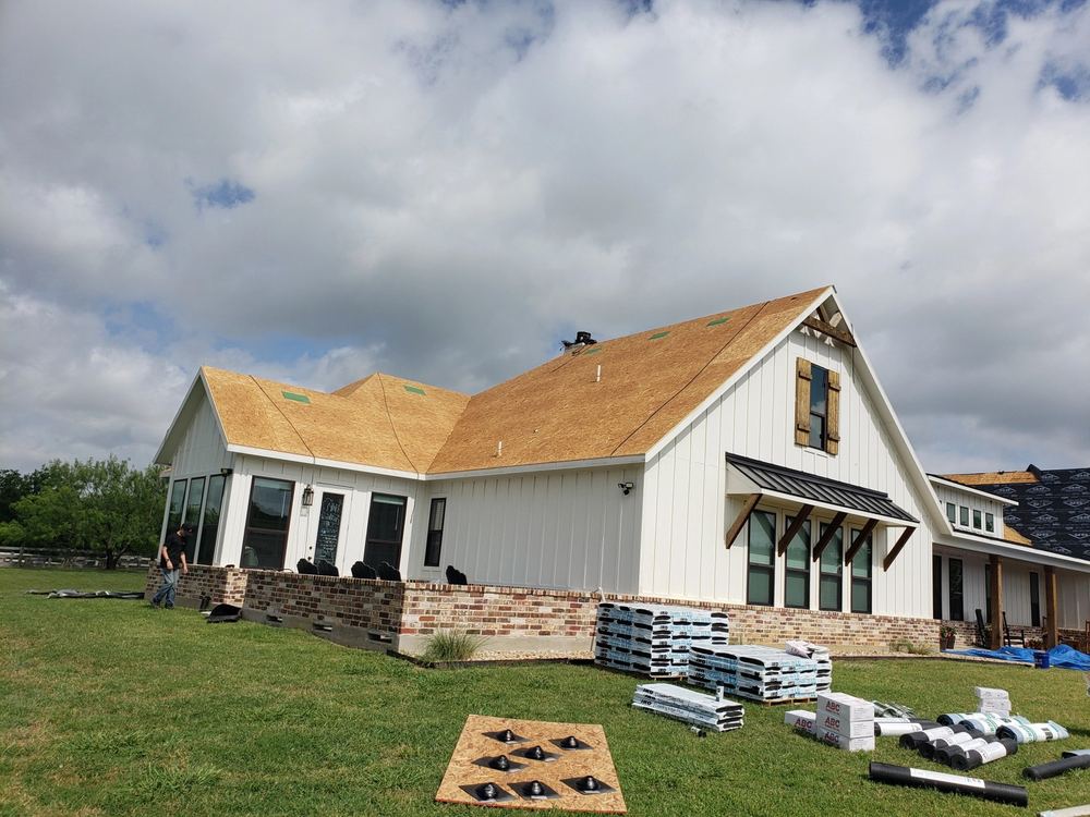 Fresh plywood roof decking ready for underlayment on a farmhouse-style home
