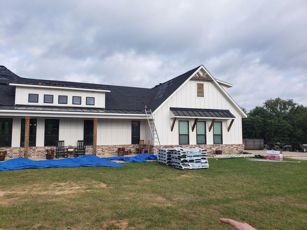 Home exterior with siding and roofline going up together, materials staged on site